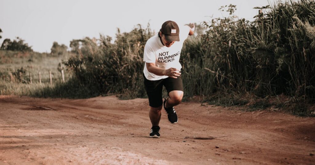 A man in sporty attire running on a rural dirt road with vegetation.