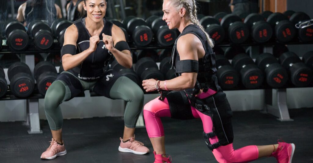 Two women engaged in strength training at a gym, showing determination.