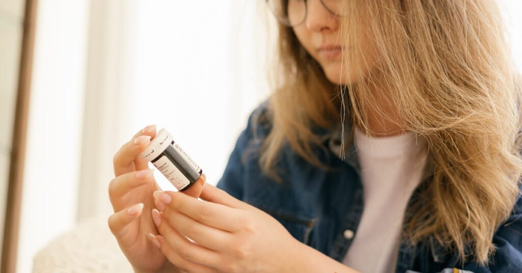 A woman carefully examines a medication bottle indoors, emphasizing health care attention.