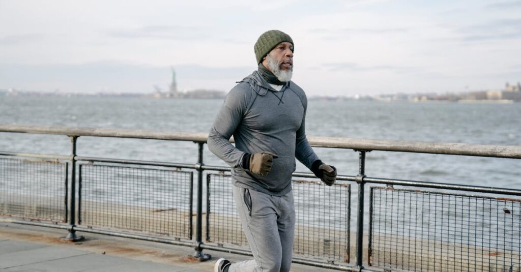 Un homme âgé en tenue de sport fait son jogging au bord de l'eau, mettant en valeur un mode de vie sain, le bien-être et la longévité.